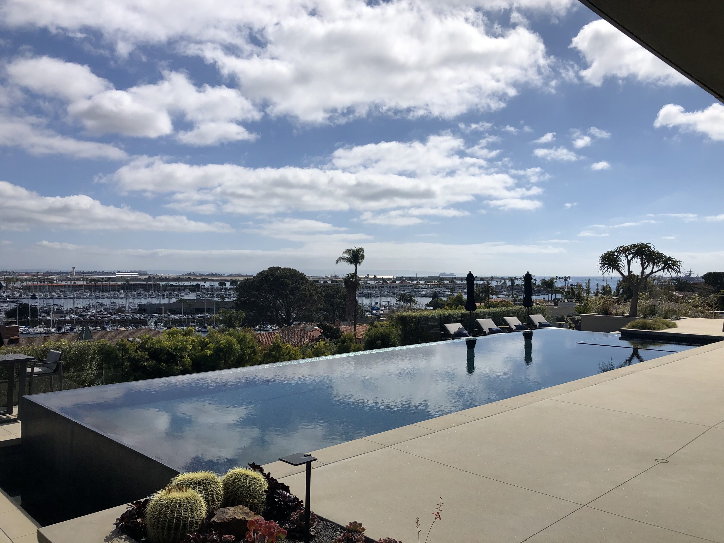 Infinity edge pool with deck and marina view