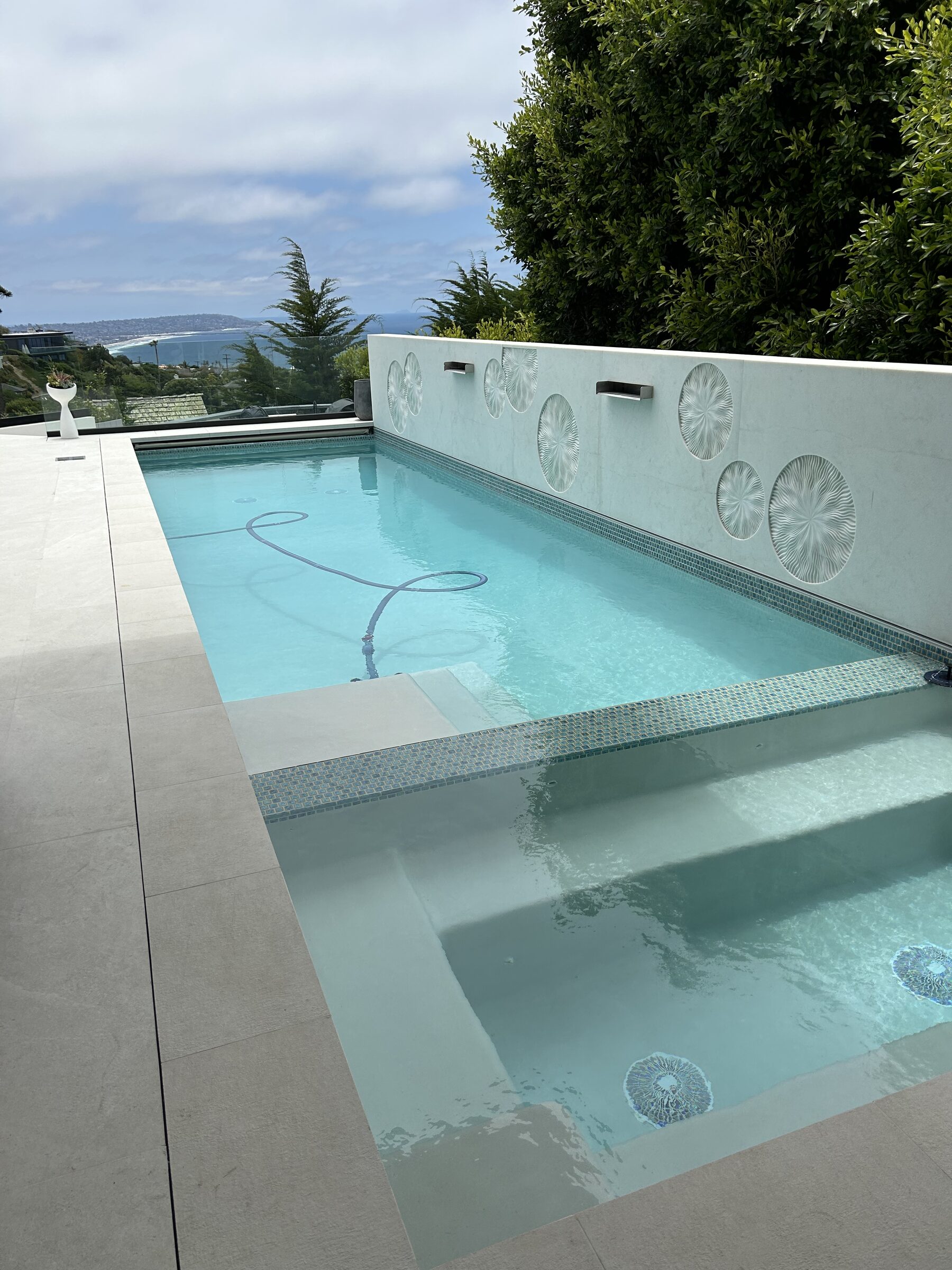 Pool medallion wall with spa and ocean view
