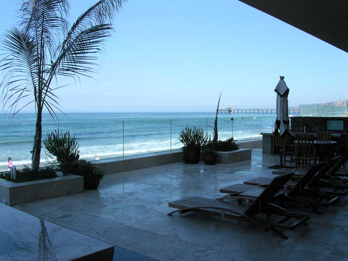 Oceanfront terrace with loungers and pier view
