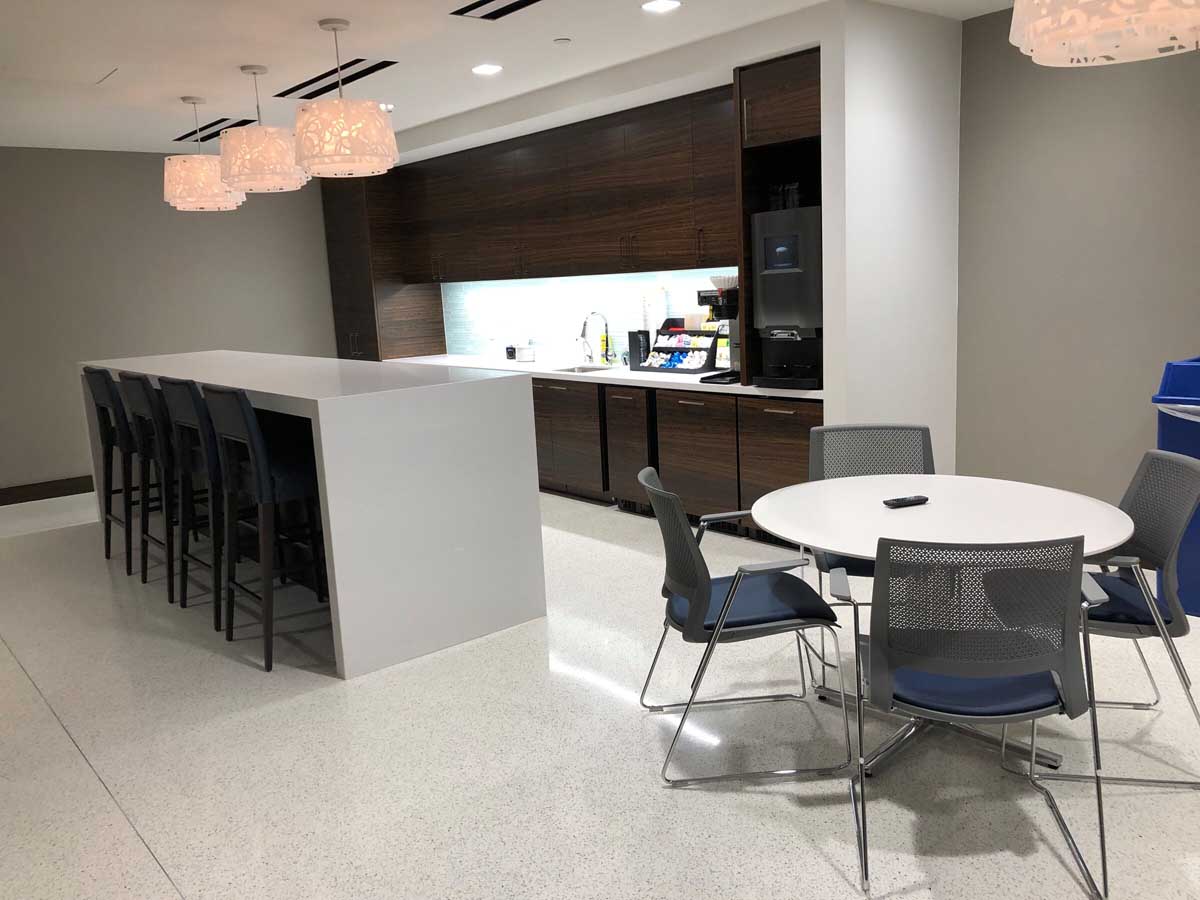 Breakroom with waterfall island and walnut cabinets